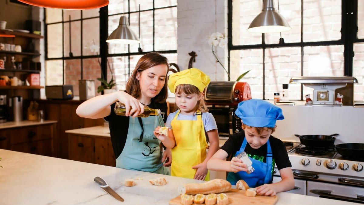 A mother and two children enjoy cooking together in a modern kitchen, creating happy family moments.