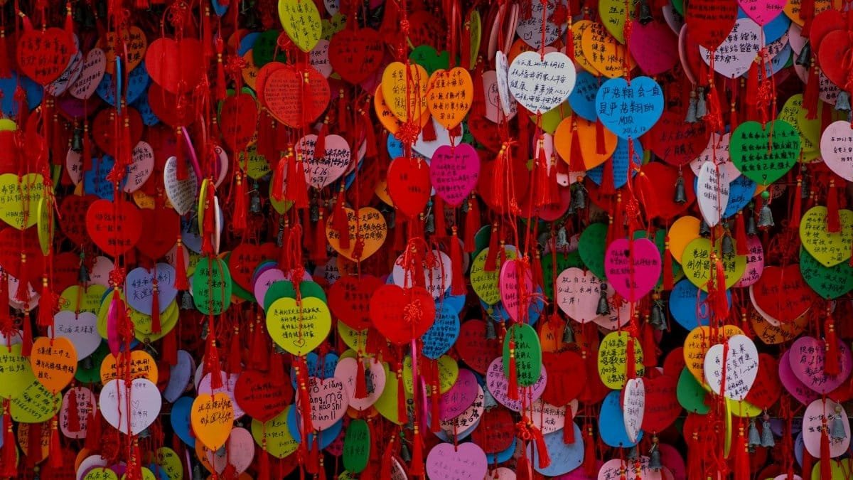 Vibrant display of heart-shaped wish cards hanging together, showcasing cultural traditions.