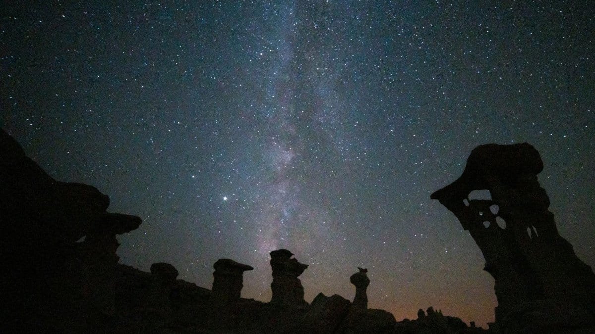 Astounding view of the Milky Way illuminating the hoodoo formations in New Mexico at night.