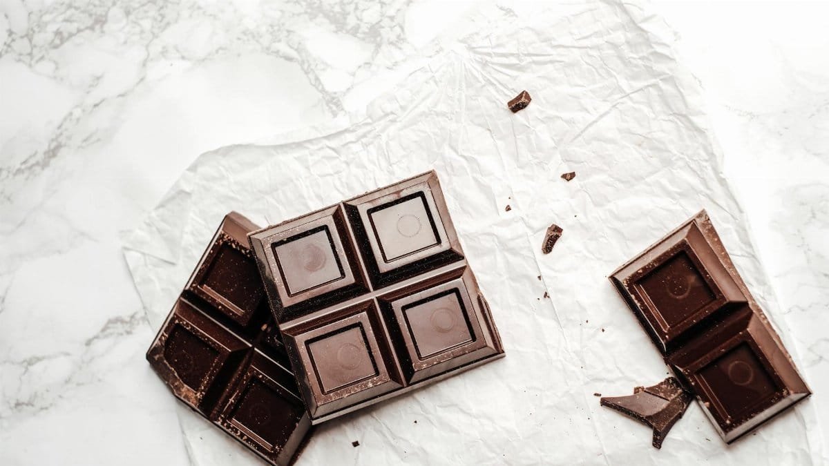 Elegant display of dark chocolate bars on a white marble surface. Perfect for dessert lovers.
