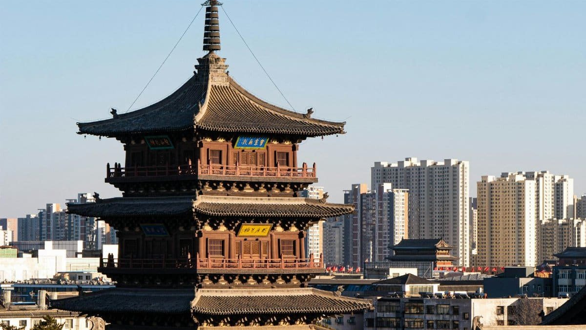 An ancient pagoda standing amidst a modern cityscape, blending tradition with urban life.