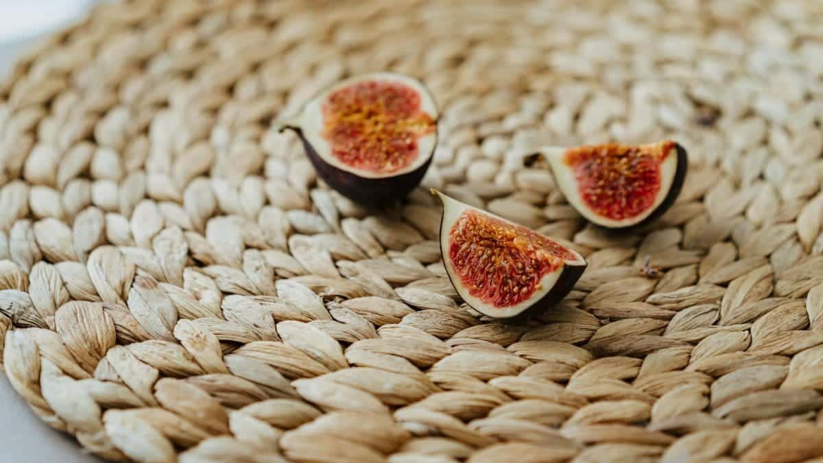 Close-up of sliced figs on a woven mat, capturing a rustic and organic feel.