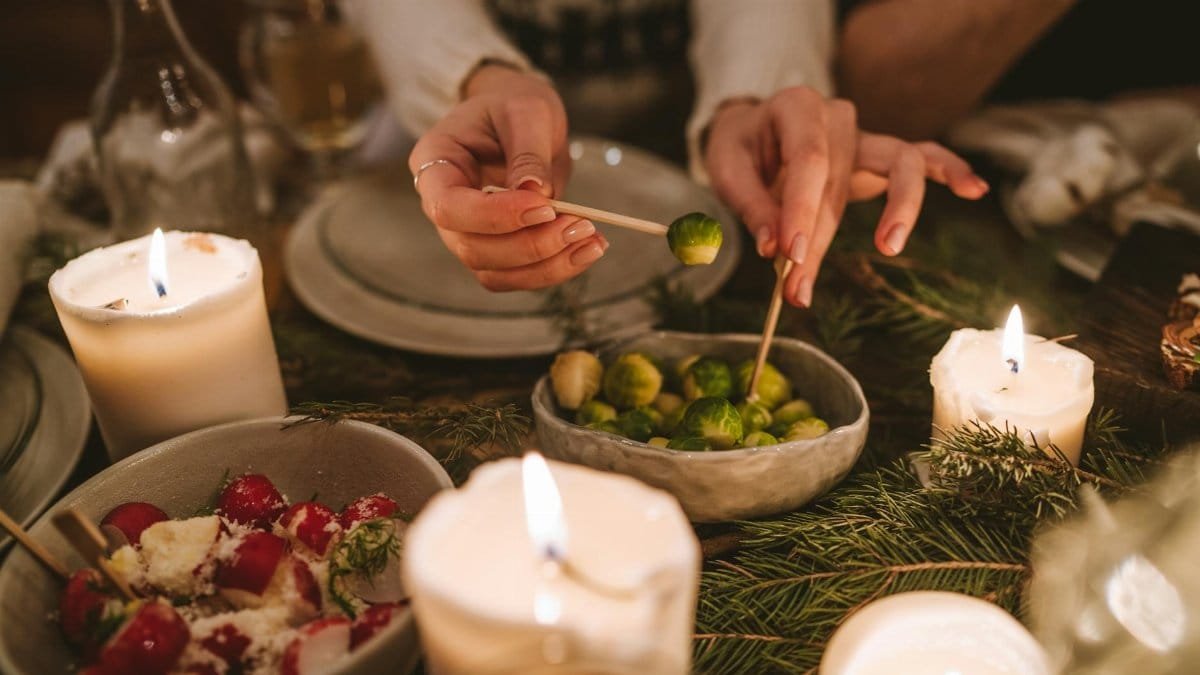 A warm table setting with candles and festive dishes, perfect for a winter holiday gathering.