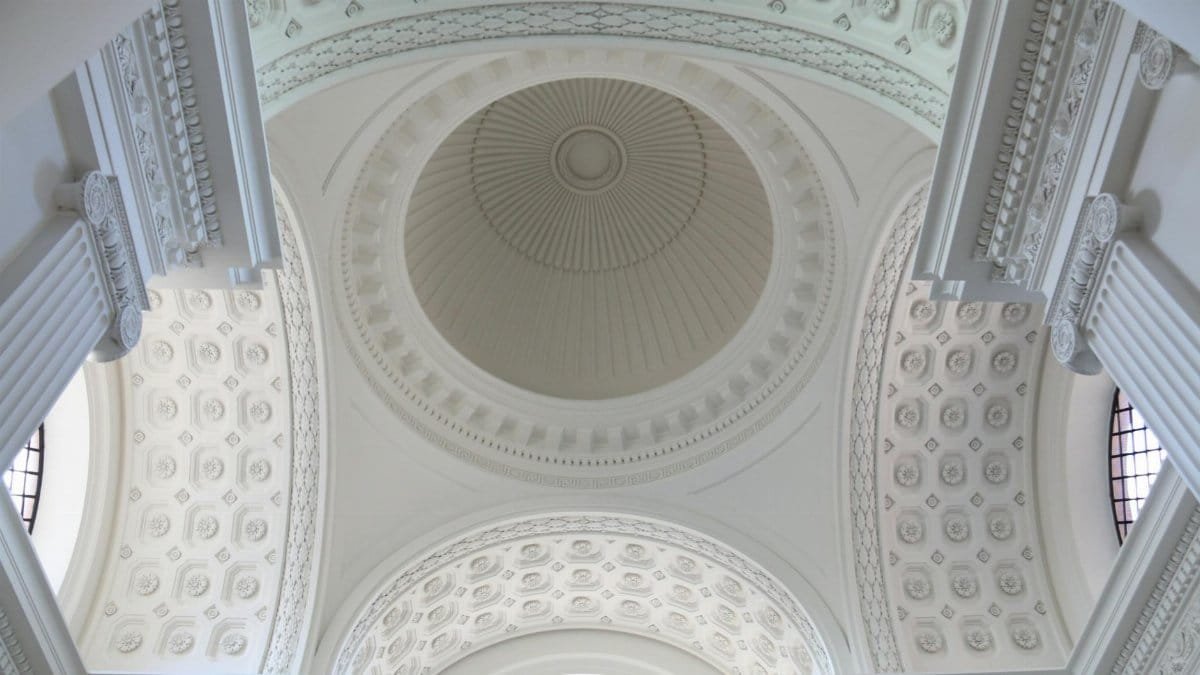 A stunning view of an ornate white dome ceiling with intricate architectural details.