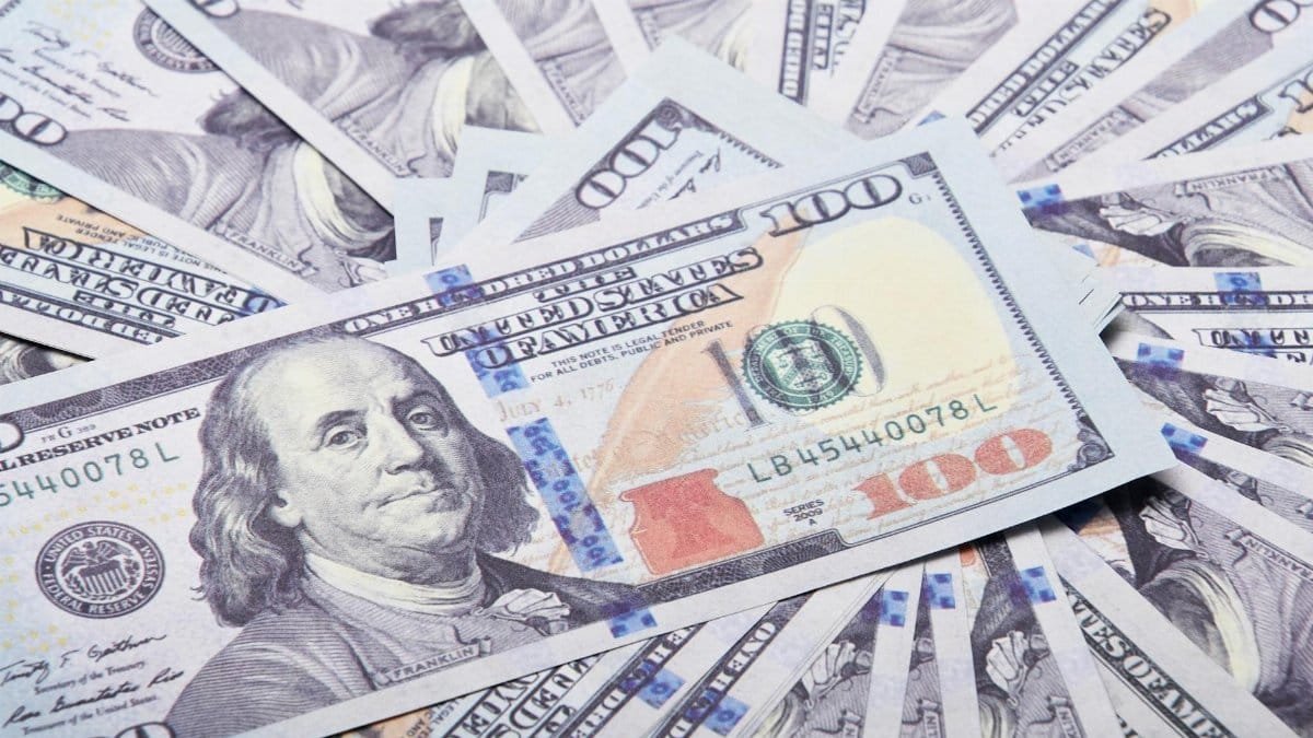 A stack of hundred dollar bills spread out, symbolizing wealth and financial success.