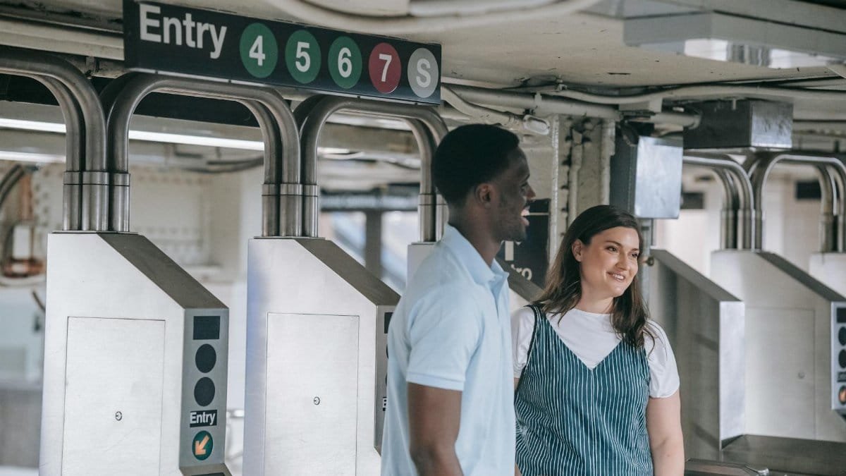 A happy couple entering a subway station, smiling and enjoying their commute.