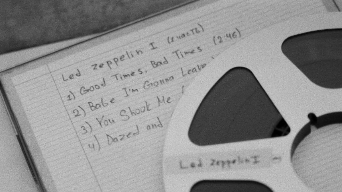 Close-up of a retro reel and handwritten music notes, evoking nostalgia.