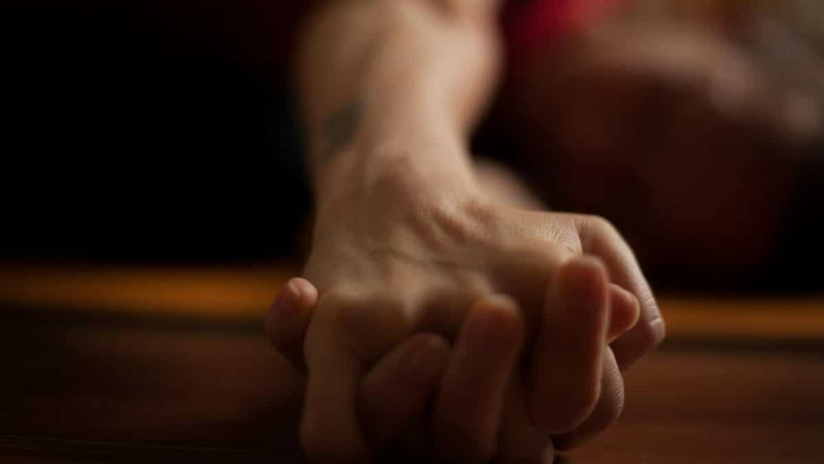 A close-up shot of two hands clasped together on a wooden surface, conveying intimacy and connection.