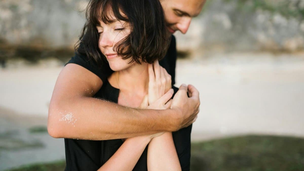 A couple embracing lovingly on a serene beach, capturing a moment of romance and connection.