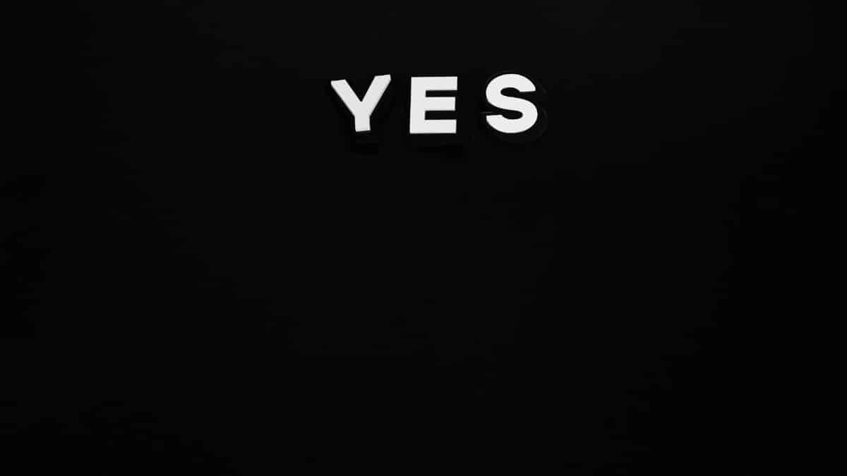 Bold white 'YES' letters on a minimalist black background, conveying positivity and affirmation.