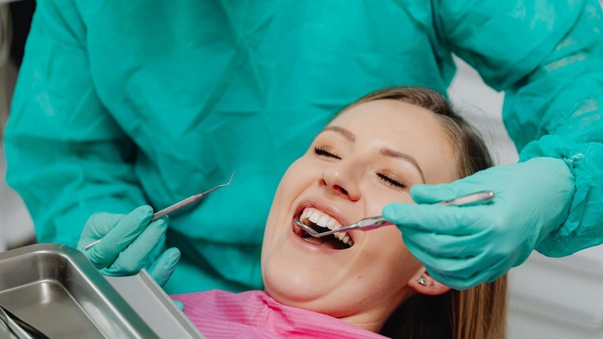 A happy woman receiving a dental examination, showing confidence in professional oral care.