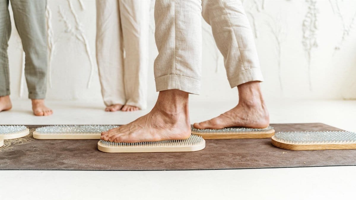 Close-up of feet on a wooden acupressure board, promoting relaxation and wellness.
