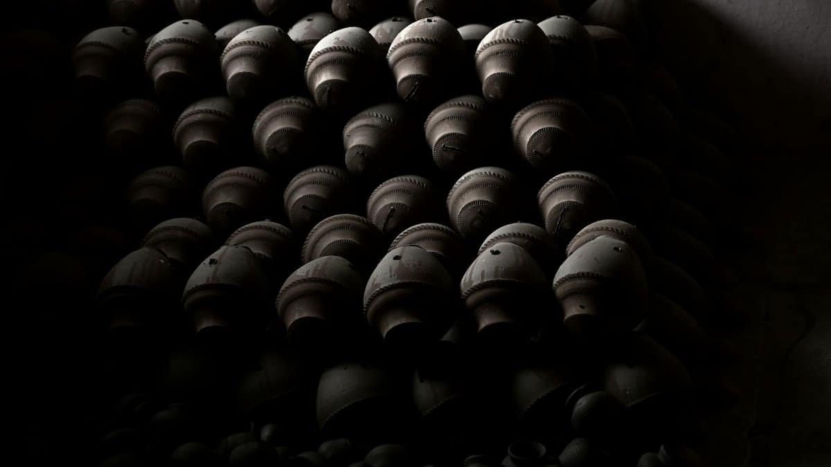 Artistic arrangement of clay pots, showcasing traditional craftsmanship in dim lighting.