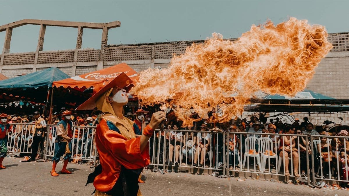 Colorful street festival with a fire breather captivating a diverse crowd.