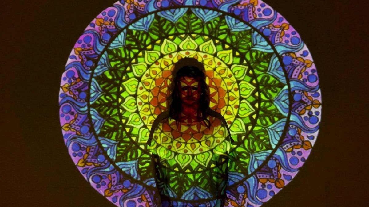 Vibrant mandala projected onto person, creating a fusion of colors and shapes.