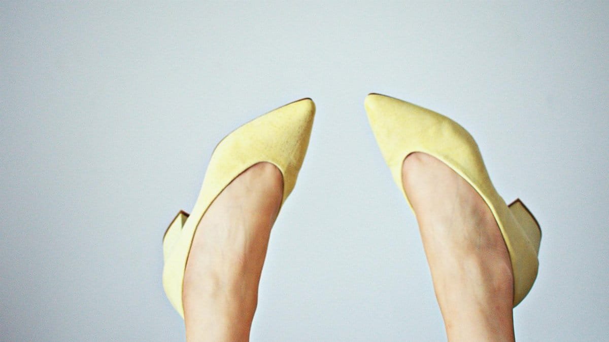 Stylish yellow high heels with a minimalist backdrop, showcasing modern fashion footwear.
