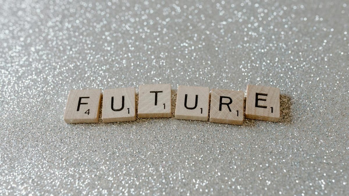 Wooden Scrabble tiles spell 'Future' against a shimmering glitter background.