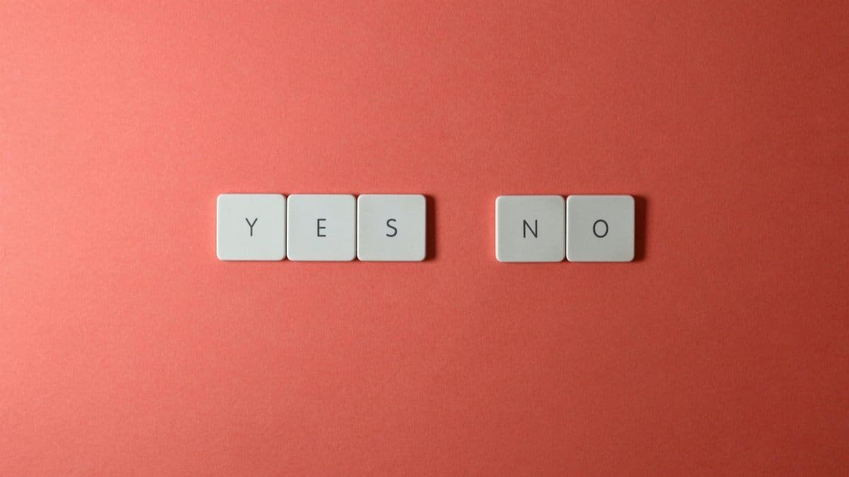 A conceptual image featuring 'yes' and 'no' text on white tiles against a red background, perfect for decision-making themes.