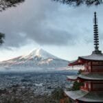 Scenic view of Chureito Pagoda with snow-capped Mount Fuji under a cloudy sky in Fujinomiya, Japan.