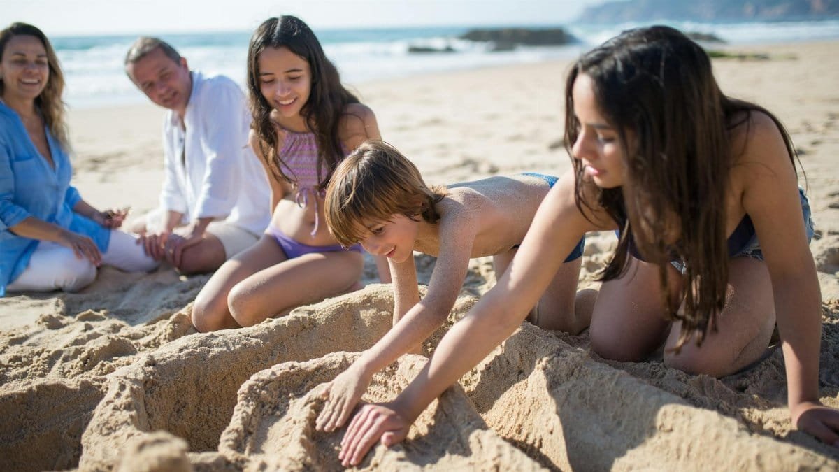 Family enjoying a playful day on the sandy beaches of Portugal.