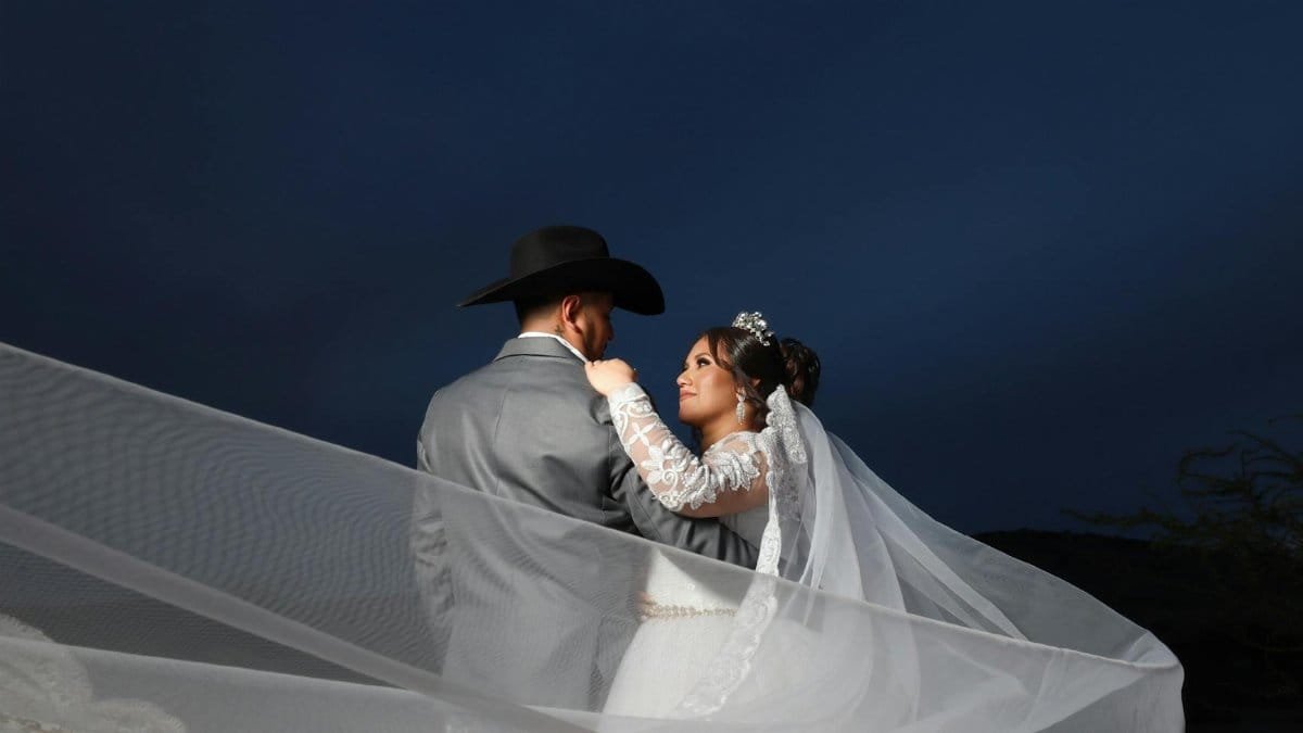 A newlywed couple embraces under the night sky in San Felipe, México.