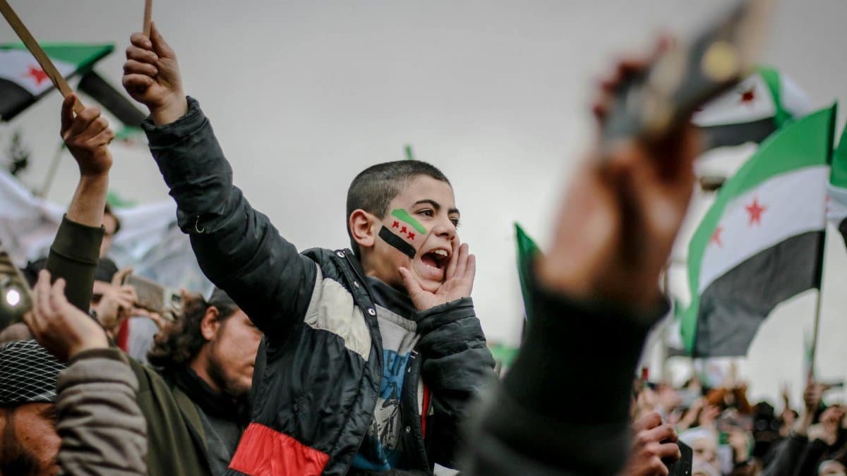Vibrant protest depicting Syrian flags and passionate participants voicing their demands.
