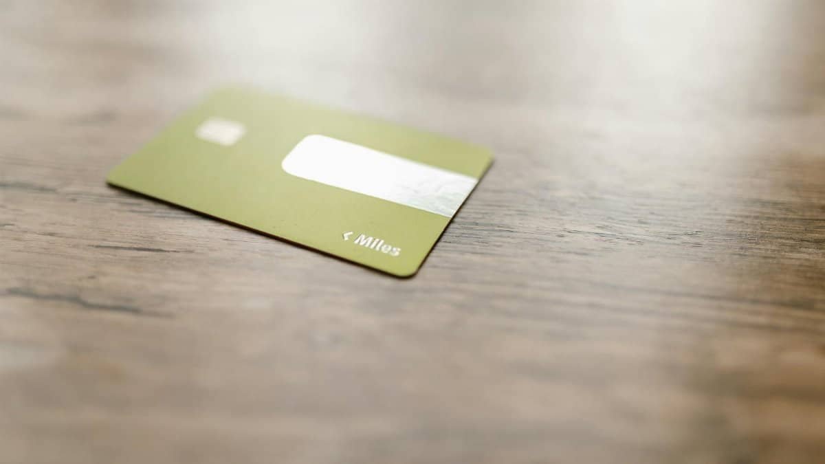 Green credit card placed on a wooden surface, captured with a blurred focus for a modern, minimalistic feel.