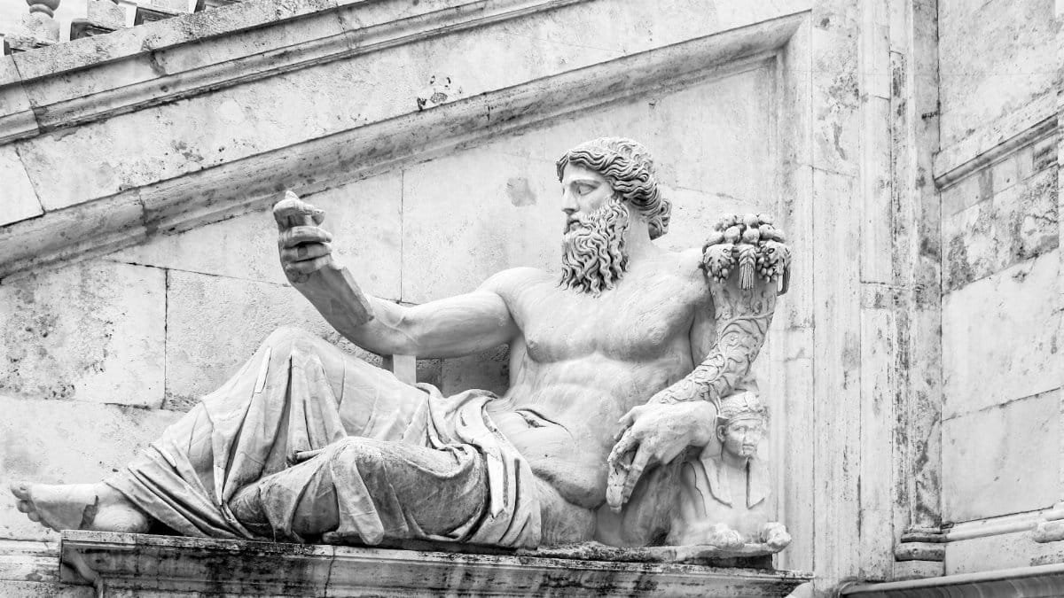 A detailed black-and-white photo of a classical marble statue depicting a reclining figure.