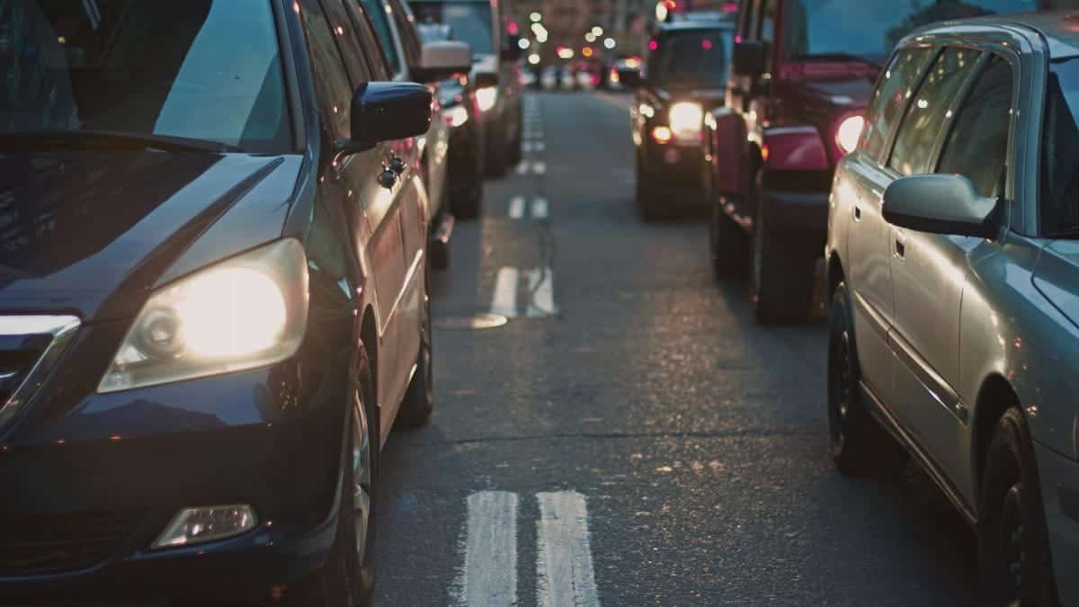 A congested city street lined with cars stuck in traffic at dusk, showcasing urban life.