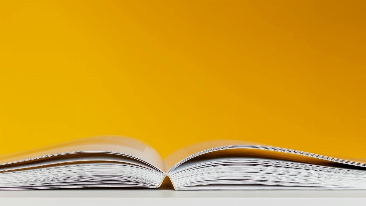 A close-up shot of an open book with a vivid yellow background, perfect for creative and conceptual design.
