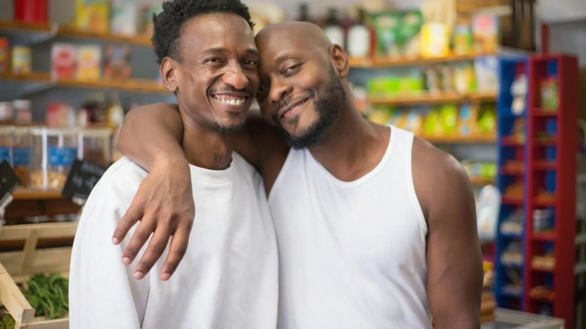 Smiling couple embracing in a grocery store aisle, portraying happiness and connection.