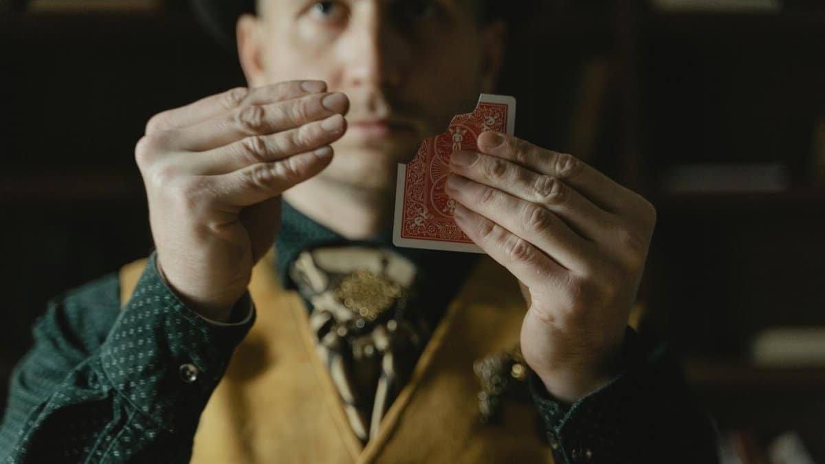 A magician skillfully performs a close-up card trick, adding mystery and intrigue.