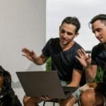 Twin brothers and Bernese Mountain Dogs engaged in an online session outdoors.