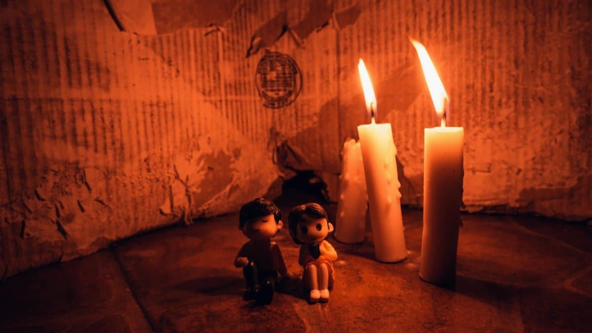 A warm candlelit setting featuring small figurines in a cozy still life arrangement.