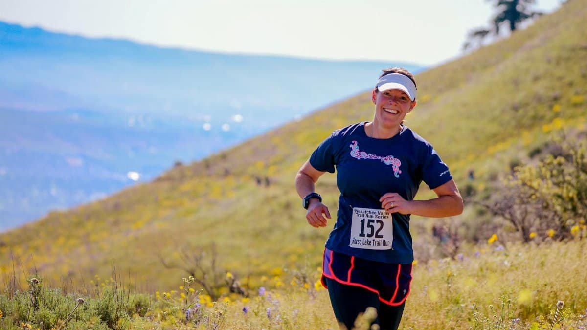 Woman enjoying a trail marathon in the vibrant hills of Wenatchee, Washington.