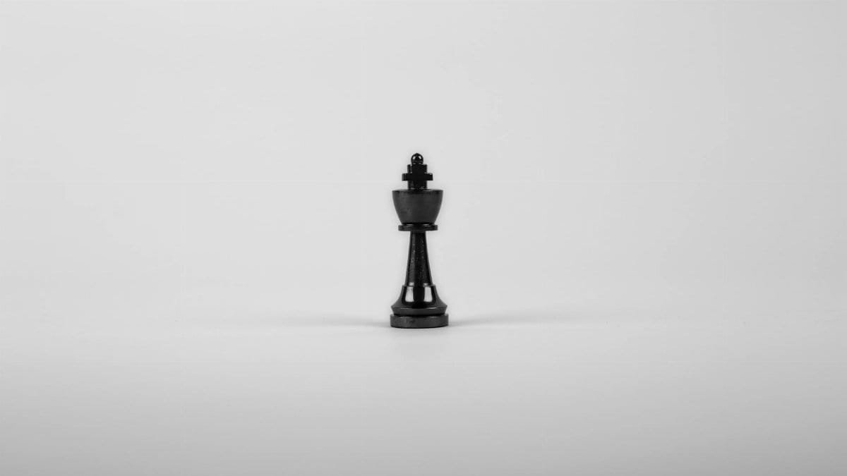 A minimalist black chess king piece on a white background, representing strategy and power.