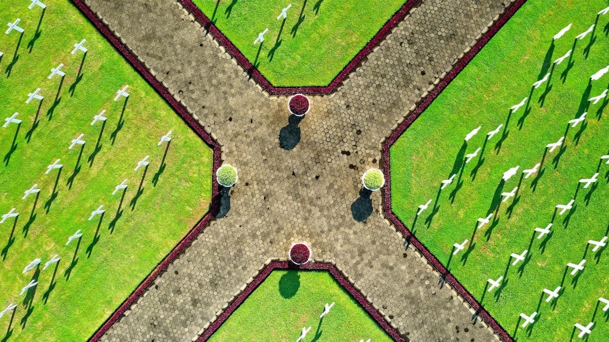 Drone shot of cemetery with cross rows and symmetrical pathways in Jakarta.