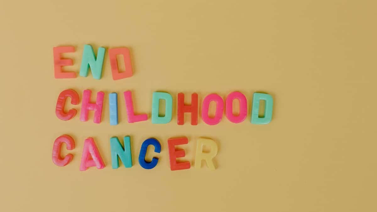 Colorful letters spelling 'End Childhood Cancer' on a yellow background promoting cancer awareness.