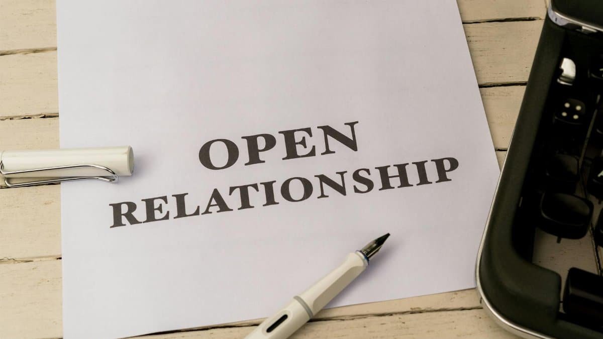 Image depicting the concept of 'Open Relationship' on paper with a pen and typewriter.