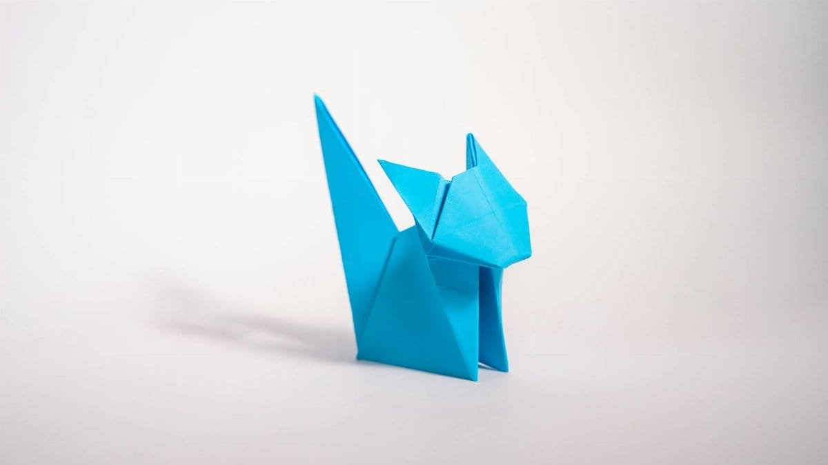 Blue origami cat figure on white background, showcasing clean minimalistic design.