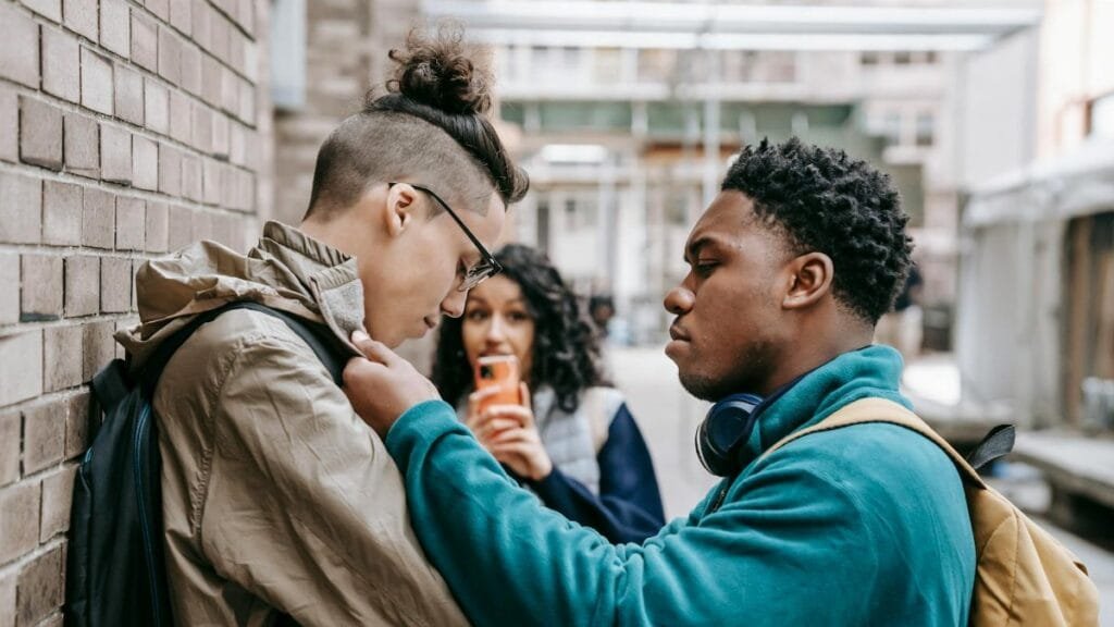 A group of diverse students involved in a conflict outdoors, showcasing social interaction dynamics.