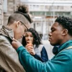 A group of diverse students involved in a conflict outdoors, showcasing social interaction dynamics.