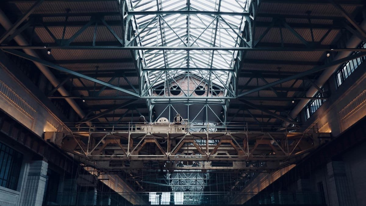 A detailed view of the intricate steel and glass roof inside Battersea Power Station in London.