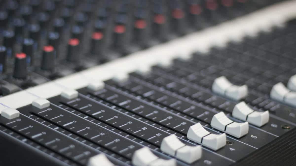 Detailed view of a sound mixer panel with sliders and knobs for audio control.
