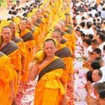 Vibrant procession of Buddhist monks and community in traditional Thai ceremony, Bangkok.
