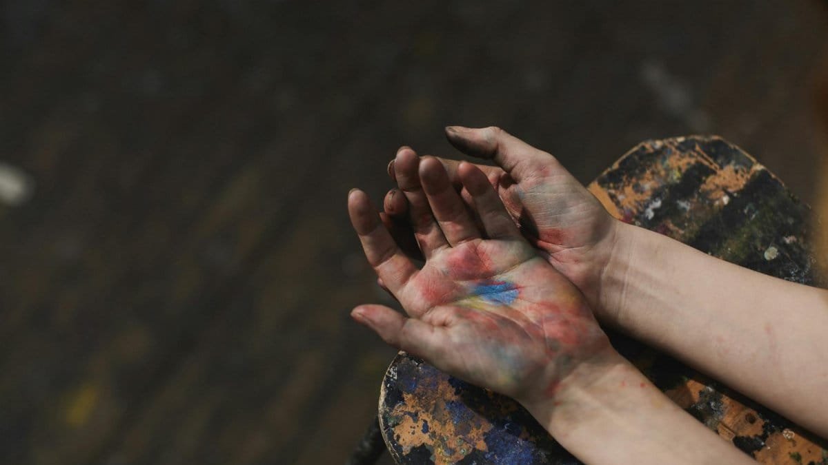 Close-up of hands covered in colorful paint, showcasing artistic creativity and expression.