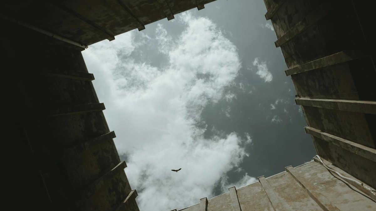 A dramatic low angle view of sky and clouds framed by architectural structure. Ideal for concepts of escape and freedom.