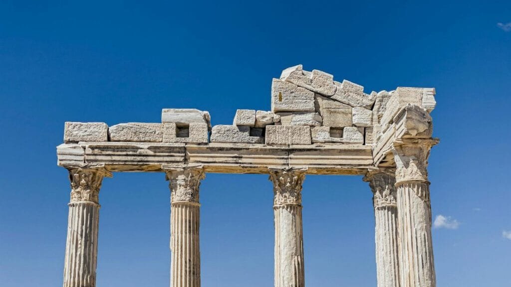 Historic Greek columns and ruins under clear blue sky. A glimpse into ancient architecture.