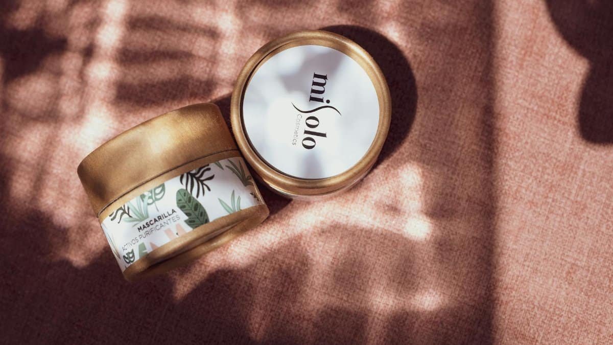 Stylish flat lay of natural skincare products with subtle shadows on a textured surface.