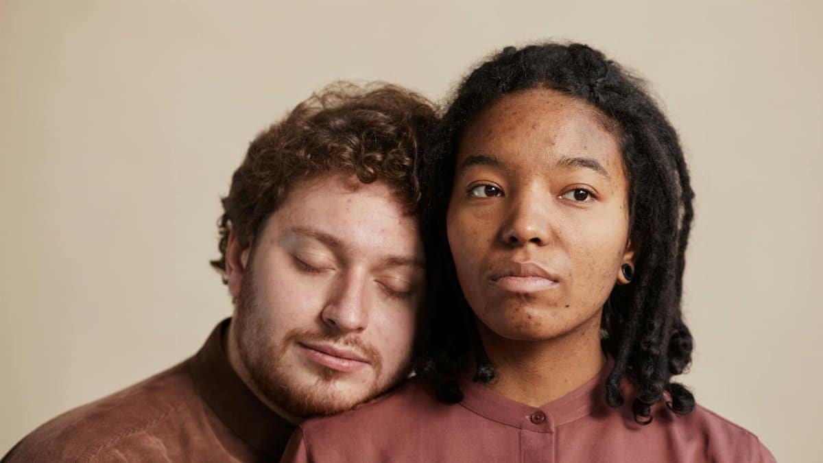 Close-up of a diverse couple sharing a tender, intimate moment indoors.